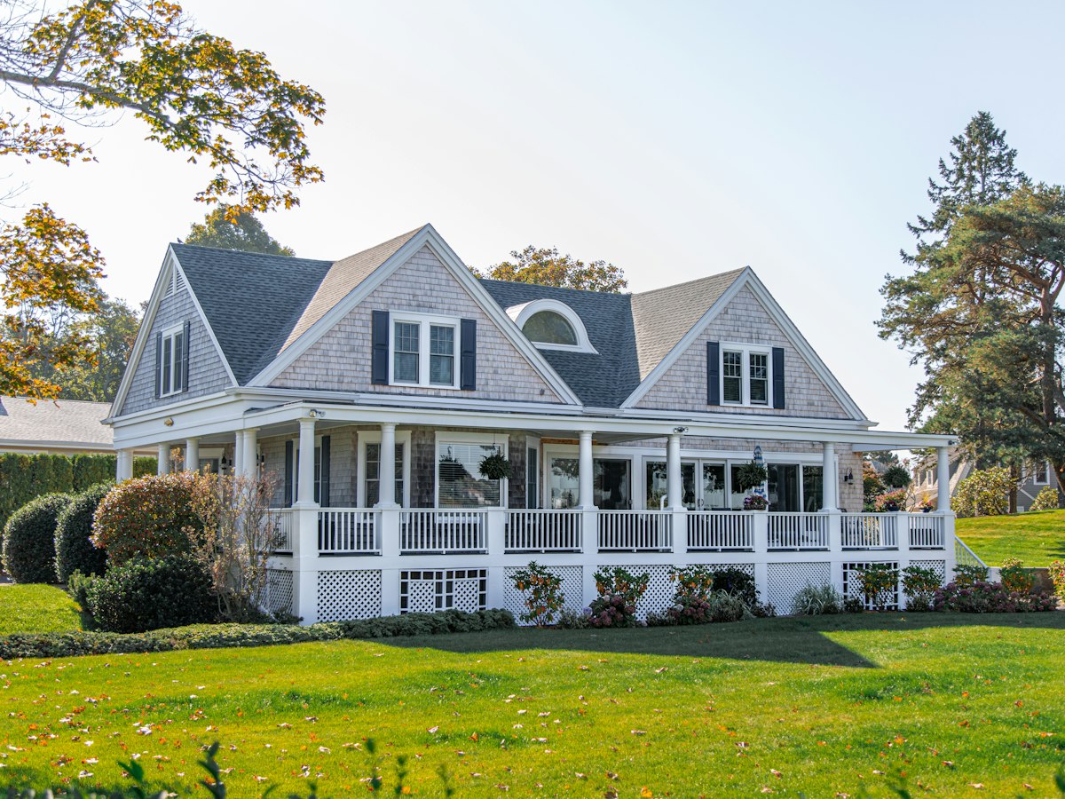Coastal-style home with cedar shake siding and wraparound porch